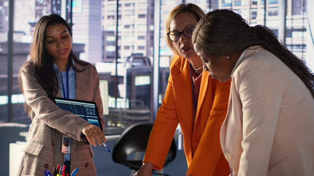 Female executives reviewing analytics on a tablet to develop a Data-Driven PR strategy in a modern office