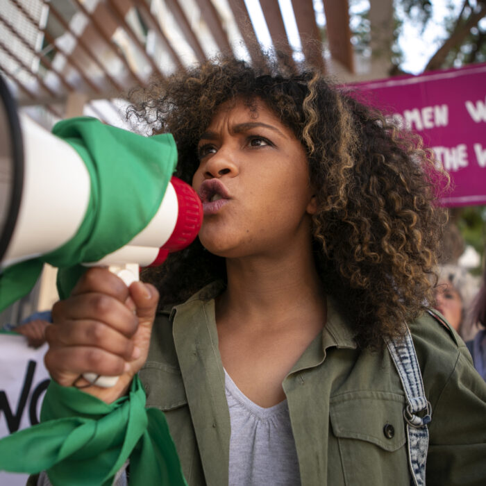 A woman marching during the crisis communication in Latam